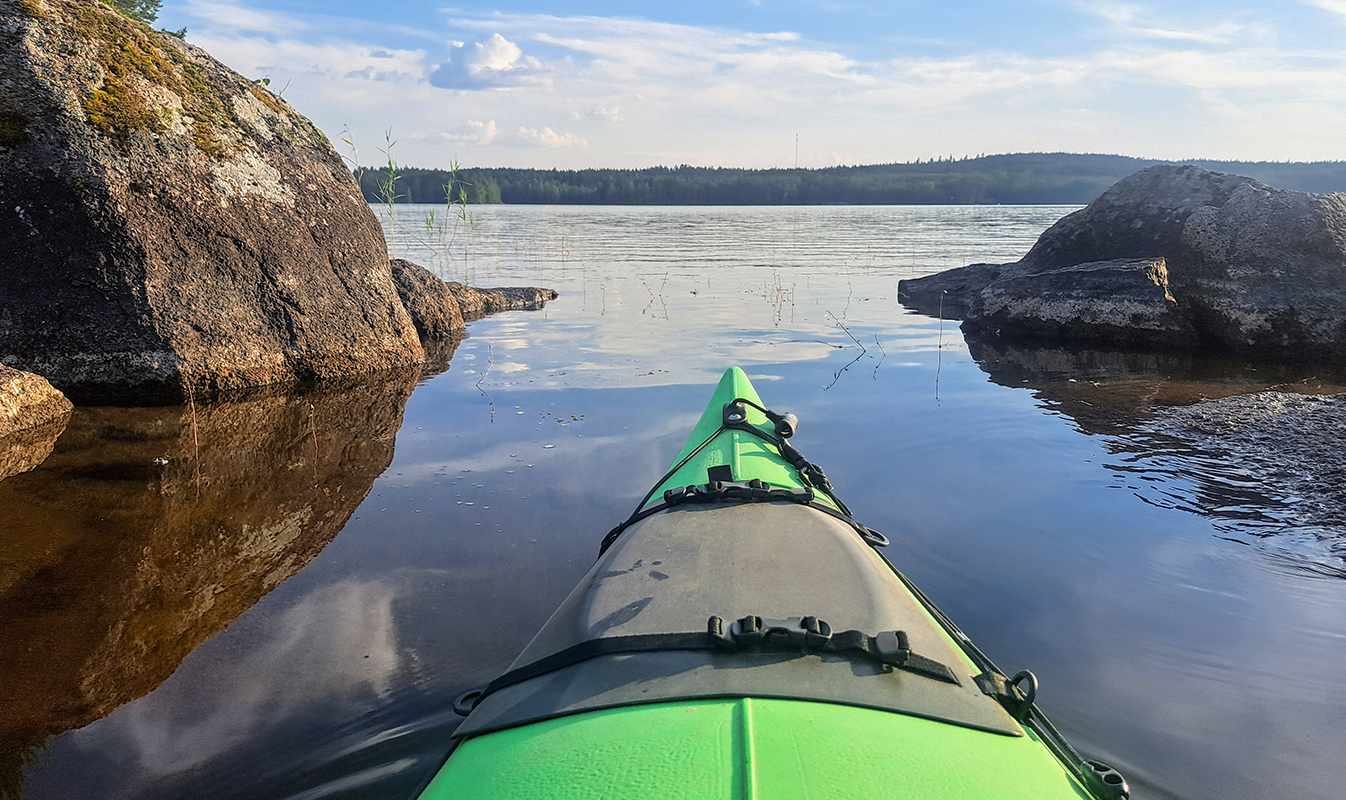 A kayak on a lake, forest on the horizon.