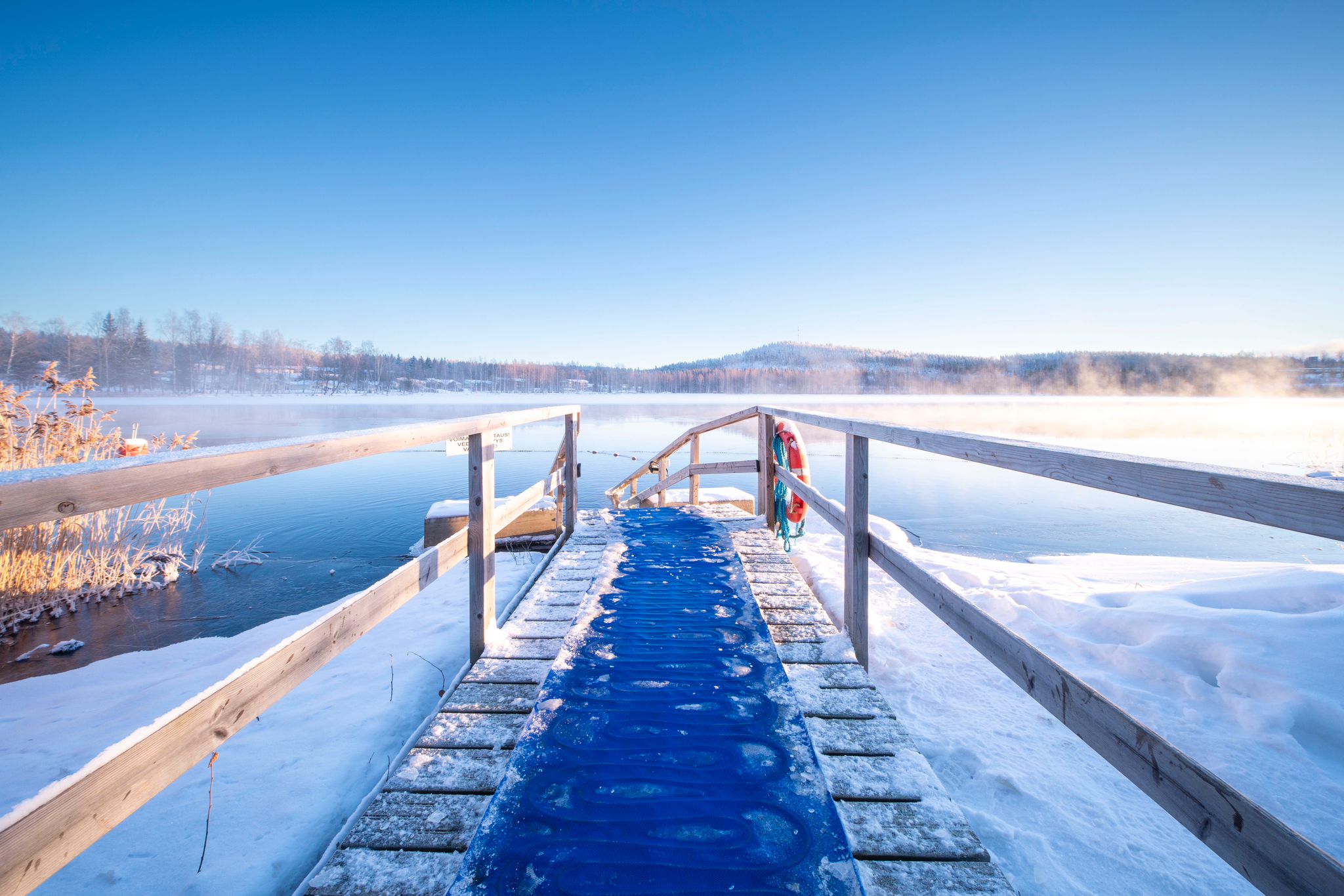 A woman heading to an ice hole to swim.