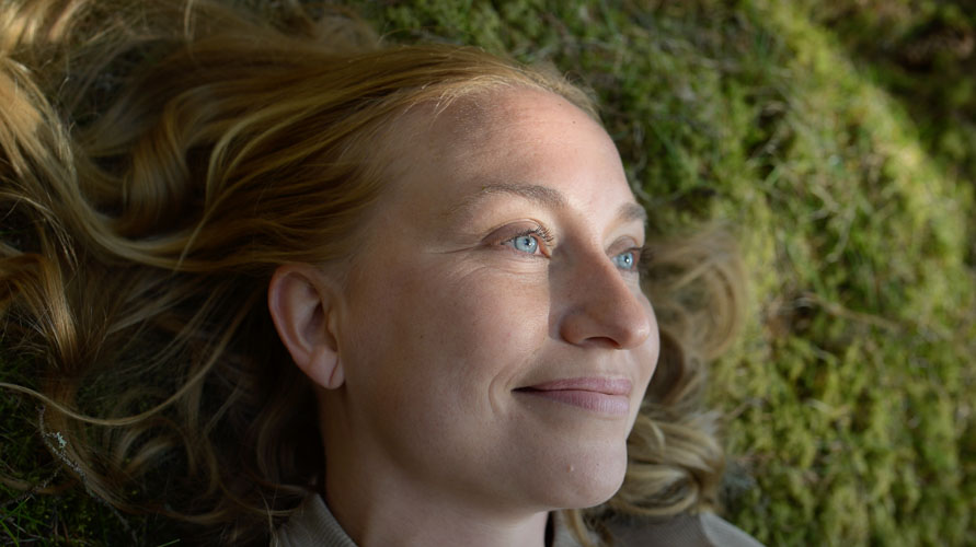 A woman lying on moss
