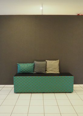 Illustrative image of a green sofa with three cushions on it.